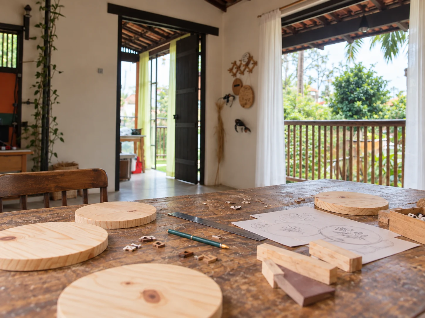 Composição do ateliê em Ilhabela, com bancada de madeira e varanda aberta